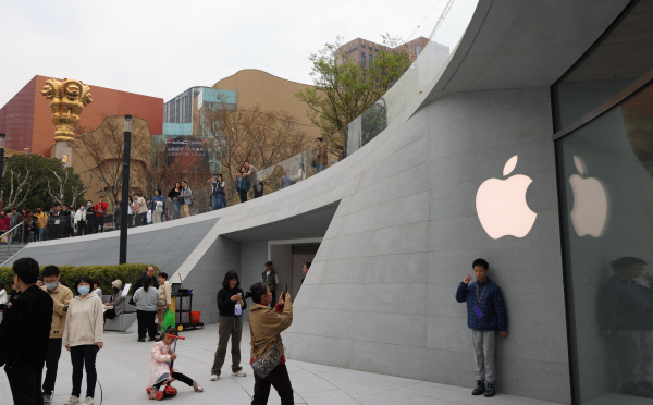 Des gens se prennent en photo devant un nouveau magasin Apple ouvert à Shanghai en mars 2023. 