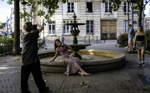 Une femme prend la pose place de l'Estrapade à Paris, l'un des lieux vus dans la série Emily in Paris. 